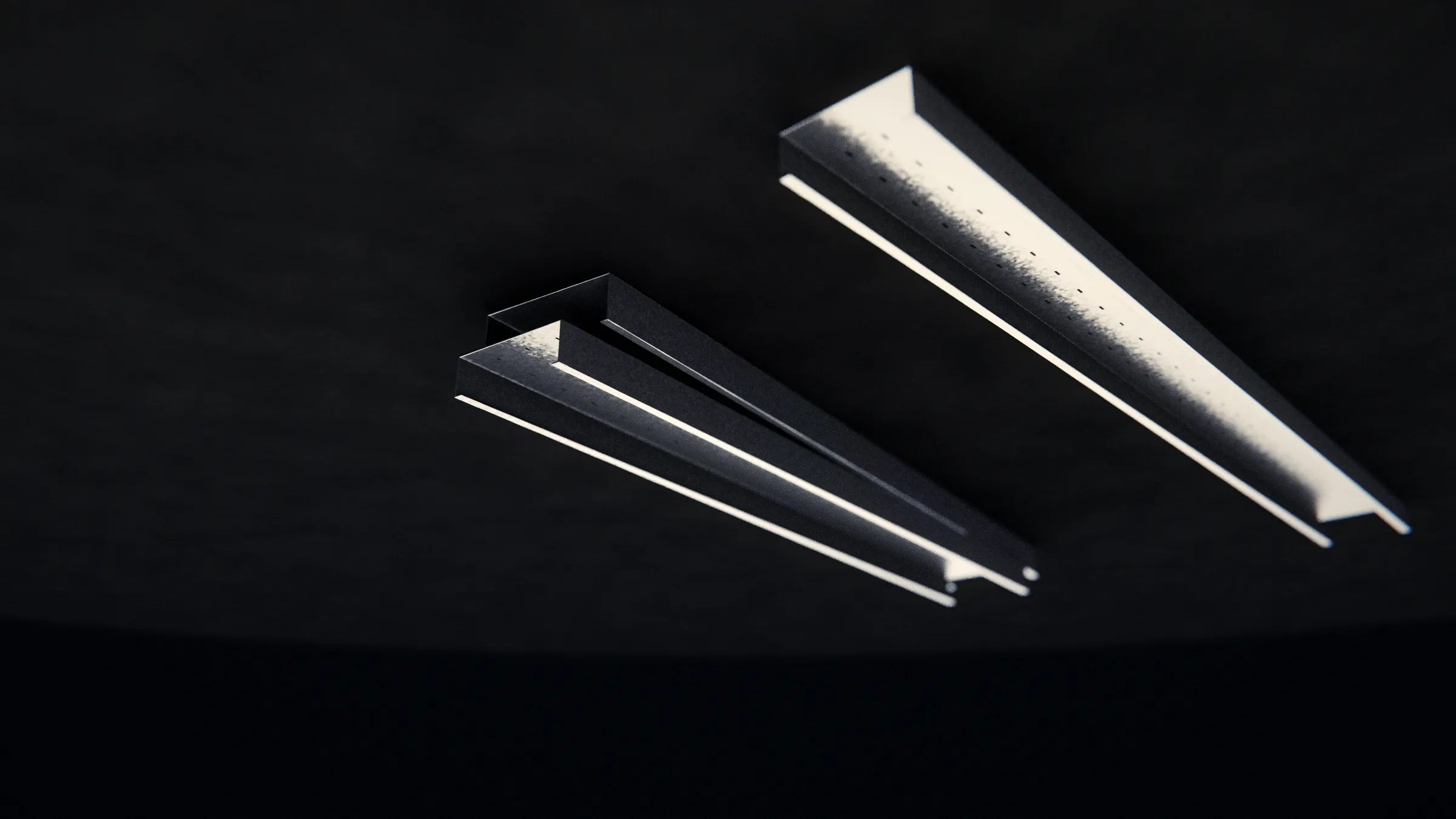 Duas eletrocalhas de perfil fechado em aço pré-galvanizado no chão da fábrica, uma delas com o fundo perfurado, iluminadas pela clarabóia do galpão
